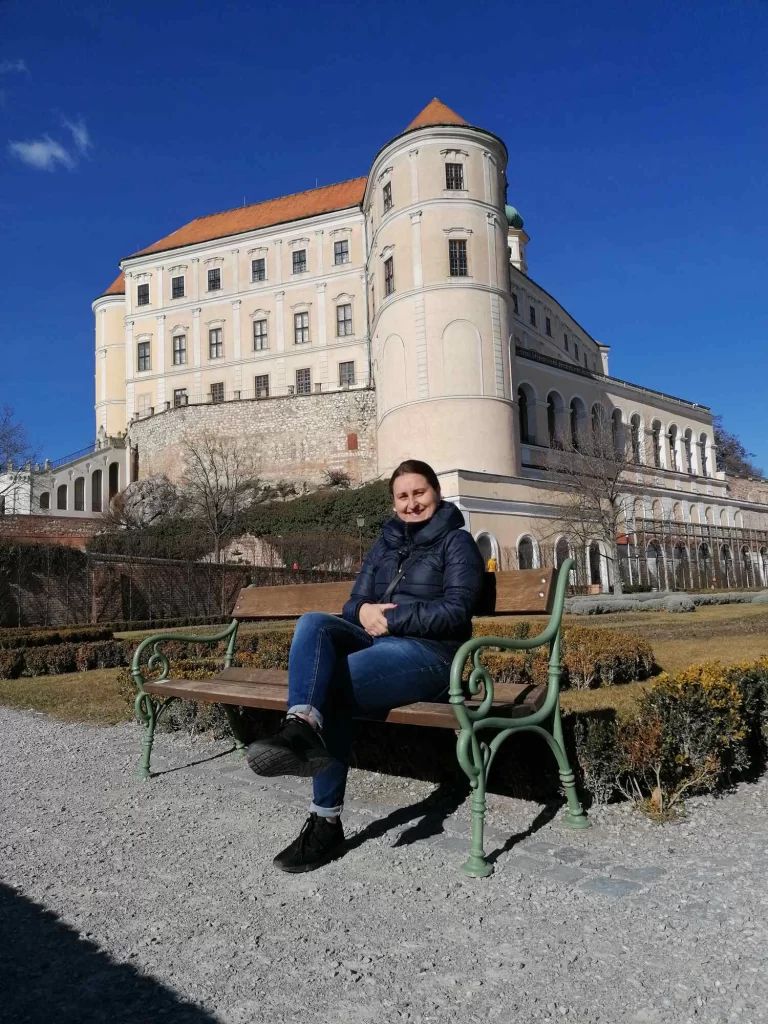 Czech teacher Daniela Grunwald sitting on the bank in castle garden in Mikulov